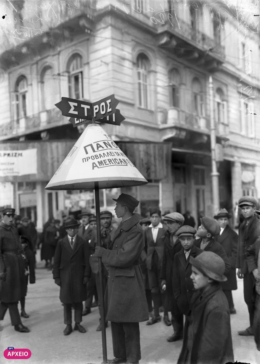 Δεκαετία του ’20. Στη συμβολή των οδών Πανεπιστημίου και Πατησίων ο τροχονόμος ρυθμίζει την κίνηση και διαφημίζει ταυτόχρονα τον κινηματογράφο Πάνθεον (φωτ. Αρχείο ΕΡΤ). 