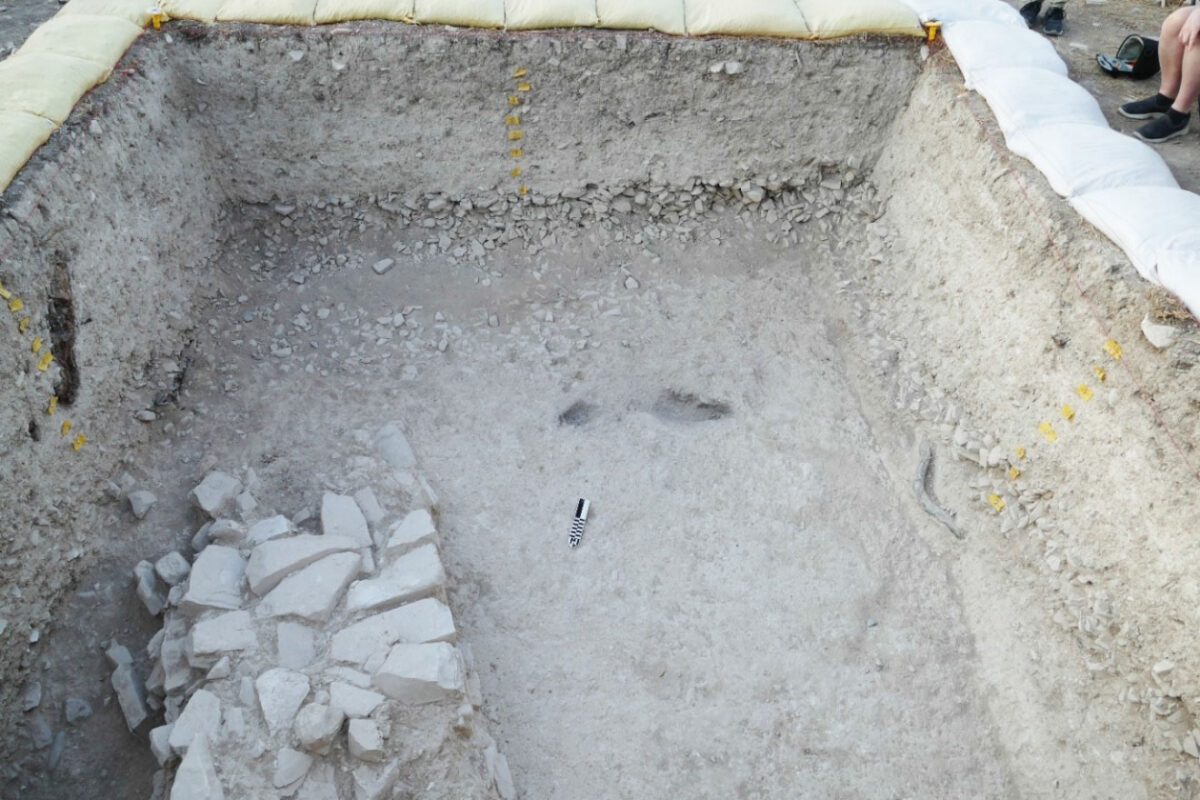 Μεγάλος τοίχος που κατηφορίζει κάτω από πυκνό στρώμα πέτρας. Σύγχρονα στρώματα δεξιά και αριστερά του τοίχου. Τετράγωνο 4M-25d, θέση Λαρούμενα. Πηγή εικόνας: Τμήμα Αρχαιοτήτων Κύπρου.