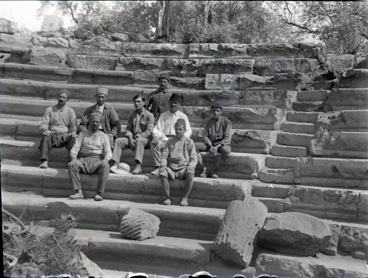 Νύσα του ποταμού Μαιάνδρου, Αύγουστος 1921. Ο νεαρός αρχαιολόγος Νικόλαος Λάσκαρης και επτά εργάτες της ανασκαφής κάθονται στα εδώλια του Γεροντικού - το αρχαίο Βουλευτήριο της πόλης. Φωτογραφικό Αρχείο Εθνικού Αρχαιολογικού Μουσείου.